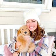 Jesse holding a golden mini-aussiedoodle puppy.